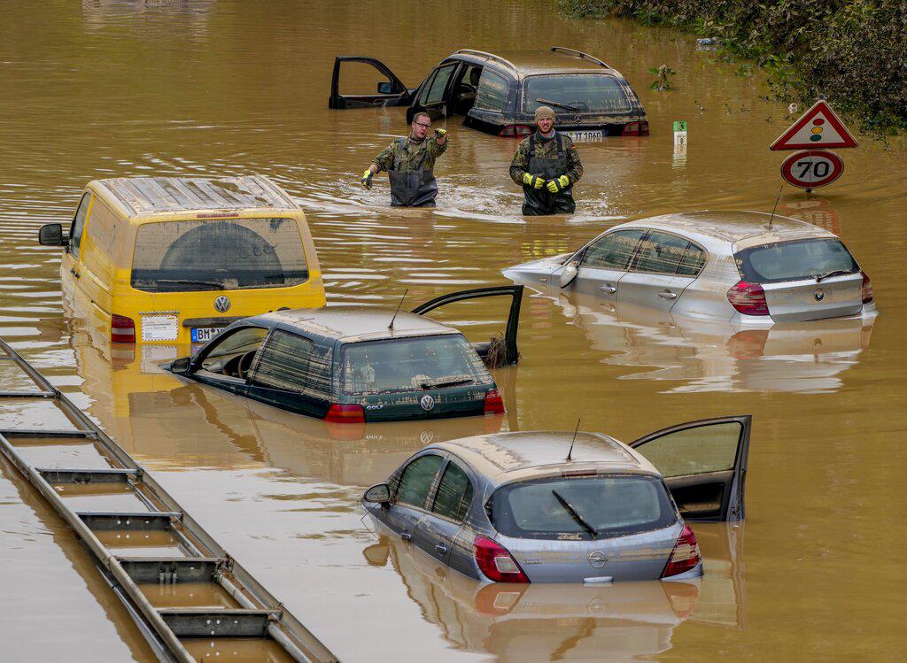 Rescatistas buscan víctimas en automóviles inundados en una carretera en Erftstadt, Alemania, el sábado 17 de julio de 2021. Debido a las fuertes lluvias, el pequeño río Erft pasó por encima de las orillas causando daños masivos. (Foto AP / Michael Probst)