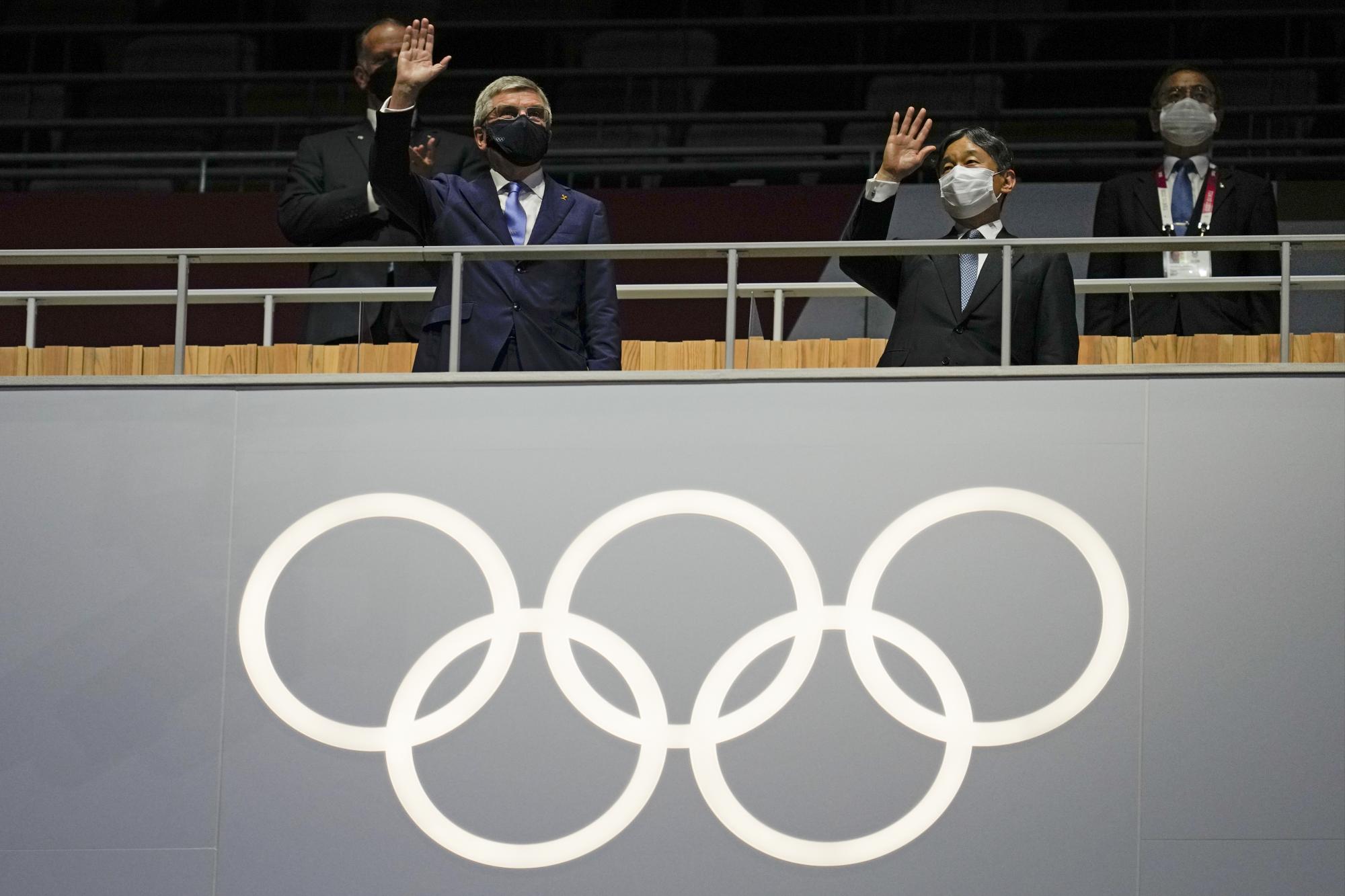 El presidente del COI, Thomas Bach, a la izquierda, saluda durante la ceremonia de apertura en el Estadio Olímpico de los Juegos Olímpicos de Verano de 2020, el viernes 23 de julio de 2021, en Tokio, Japón. (Foto AP / Natacha Pisarenko)