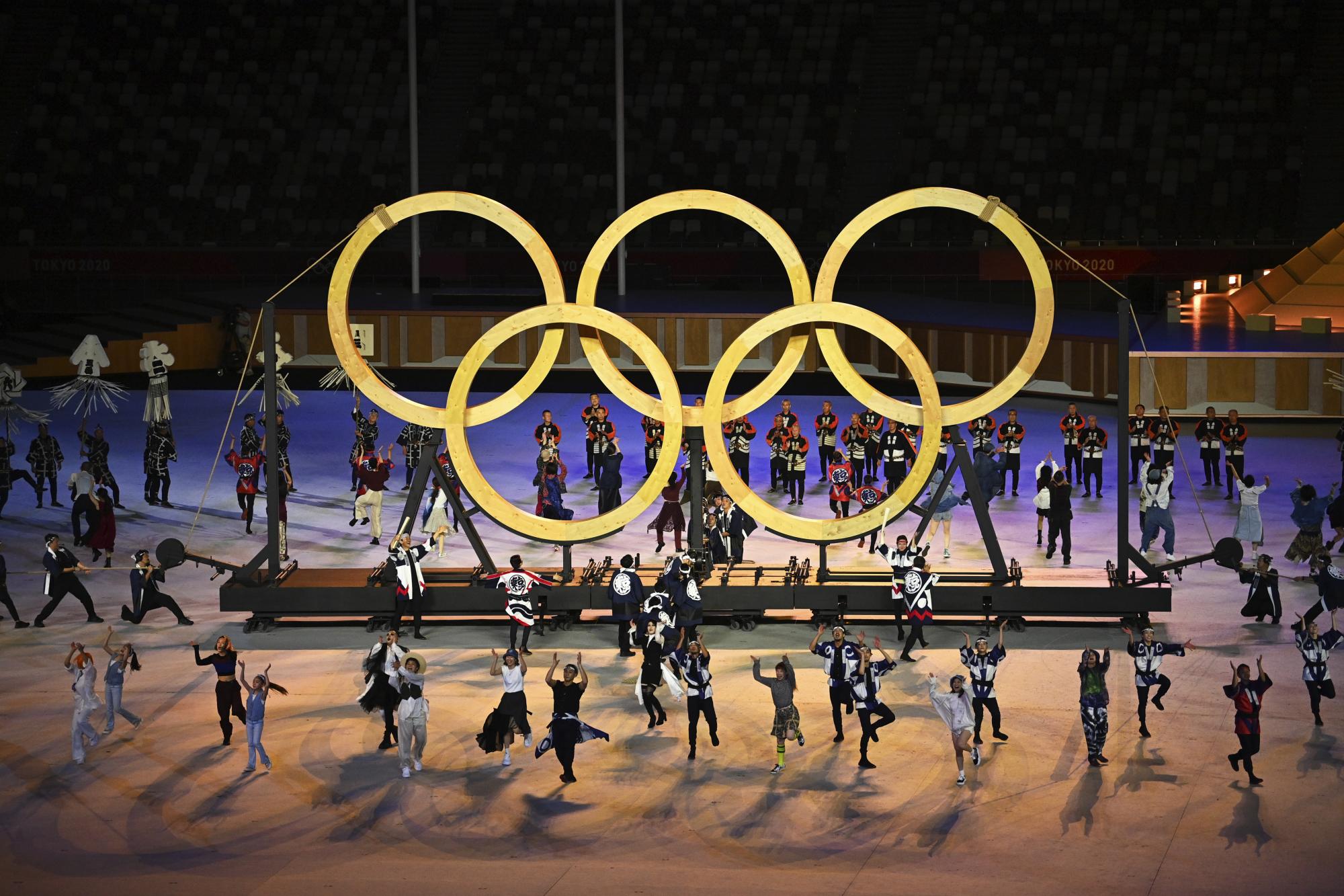 Los bailarines actúan frente a los anillos olímpicos durante la ceremonia de apertura en el Estadio Olímpico de los Juegos Olímpicos de Verano de 2020, el viernes 23 de julio de 2021, en Tokio, Japón. (Dylan Martinez / Pool Photo vía AP)