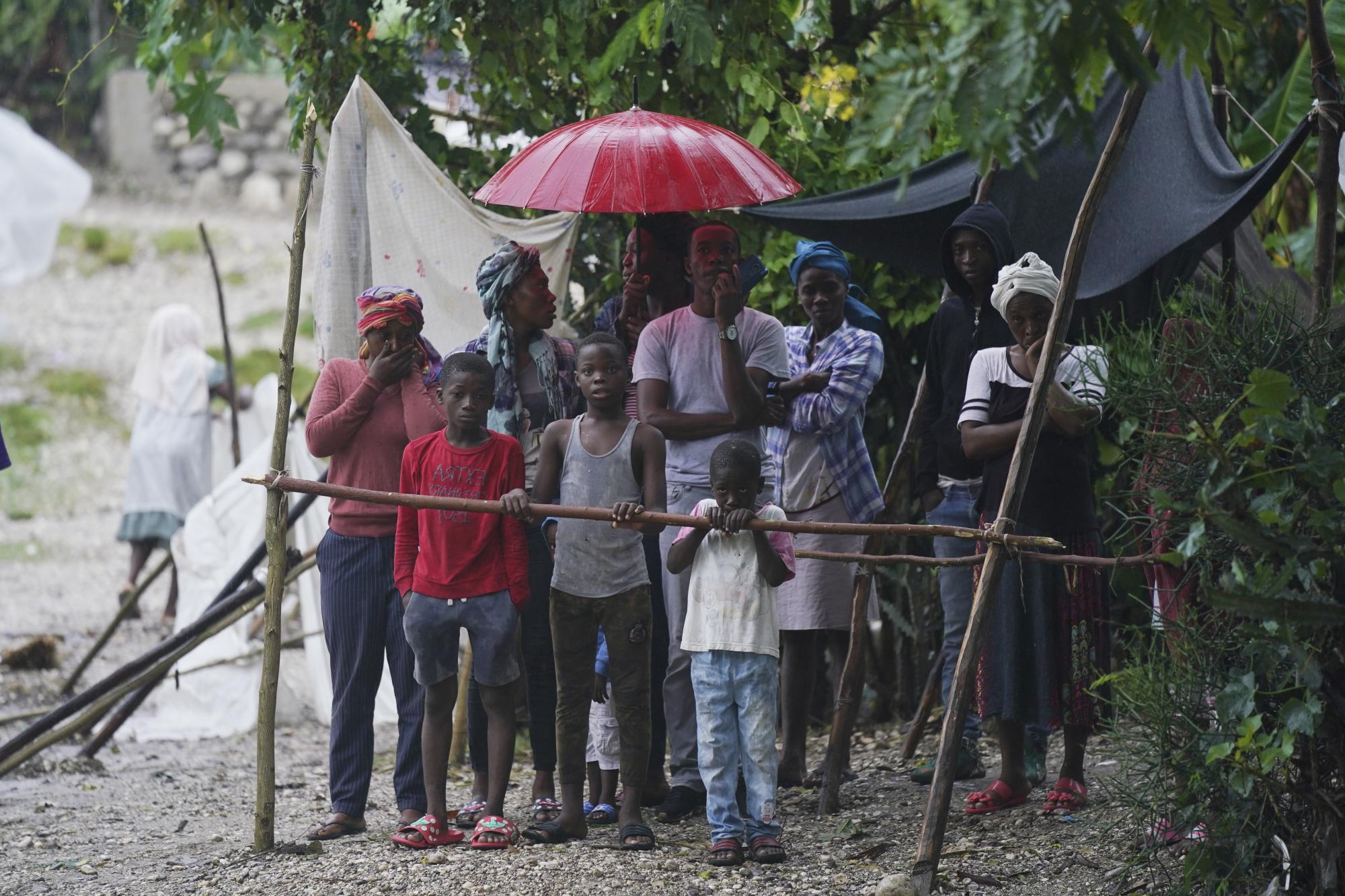 Las personas desplazadas por el terremoto están expuestas a los elementos la mañana después de que la tormenta tropical Grace azotara Les Cayes, Haití, el martes 17 de agosto de 2021, tres días después de un terremoto de magnitud 7.2. (Foto AP / Fernando Llano)