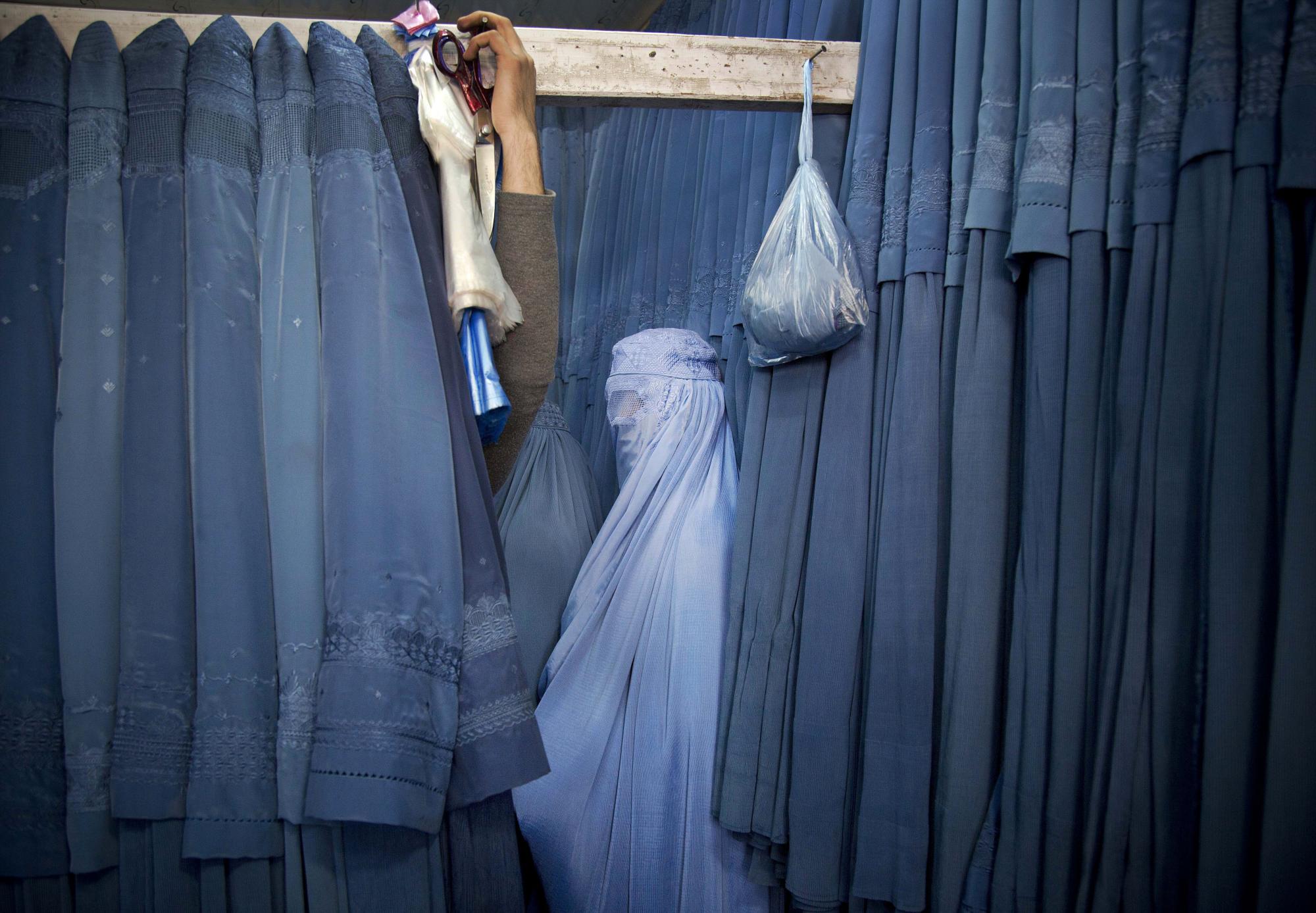 Una mujer afgana espera en un vestuario para probar un nuevo burka, en una tienda en la ciudad vieja de Kabul, Afganistán, el jueves 11 de abril de 2013. Antes de que los talibanes tomaran el poder en Afganistán, el burka se usaba con poca frecuencia en las ciudades. Mientras estuvieron en el poder, los talibanes exigieron el uso de un burka en público. (Foto AP / Anja Niedringhaus)