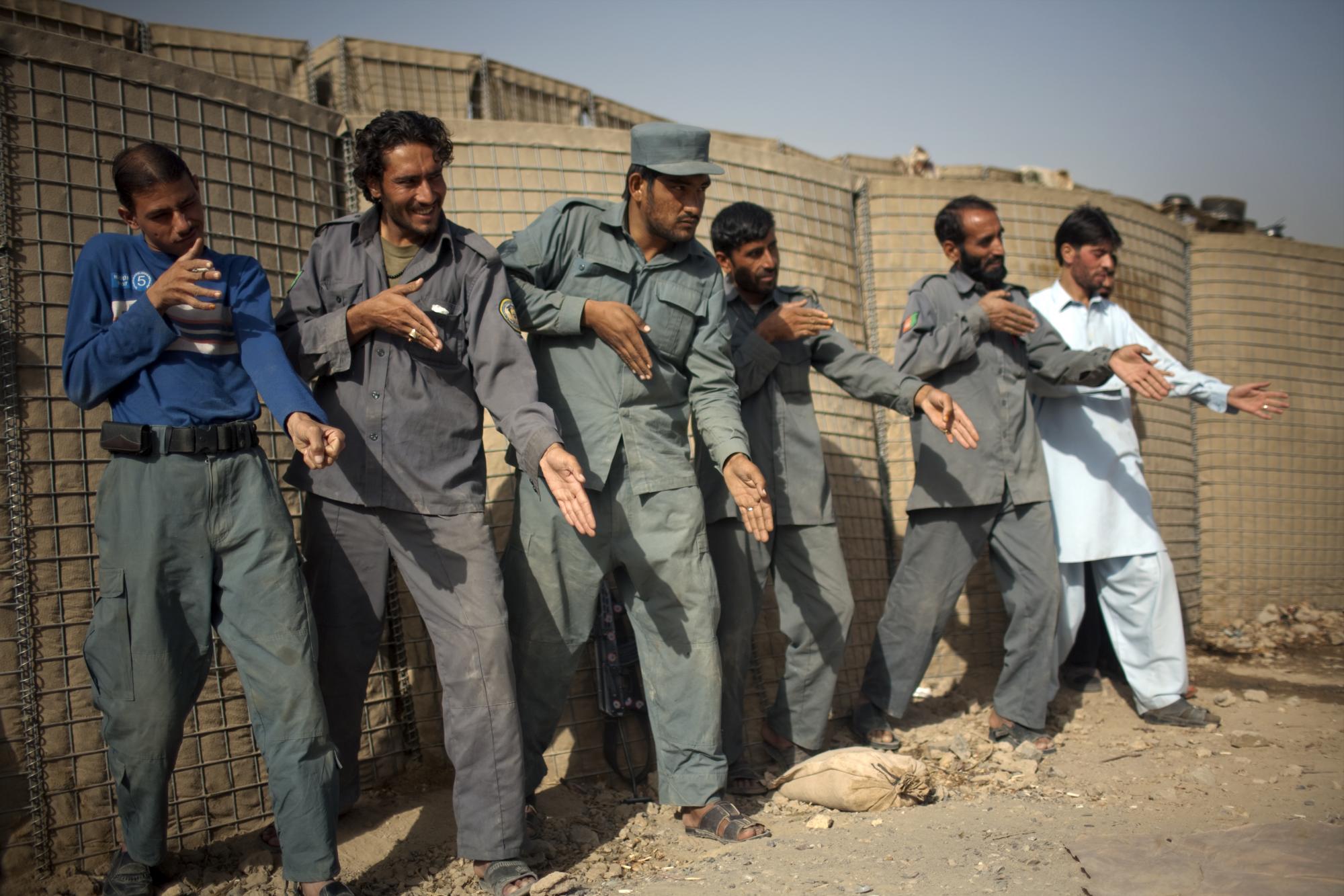 Policías afganos simulan orientación sobre armas durante una sesión de entrenamiento con soldados estadounidenses de la 2.a Compañía de Policía Militar Diablos 552. ° PLT, en las afueras de la ciudad de Kandahar, Afganistán, el martes 26 de octubre de 2010. (AP Photo / Rodrigo Abd)