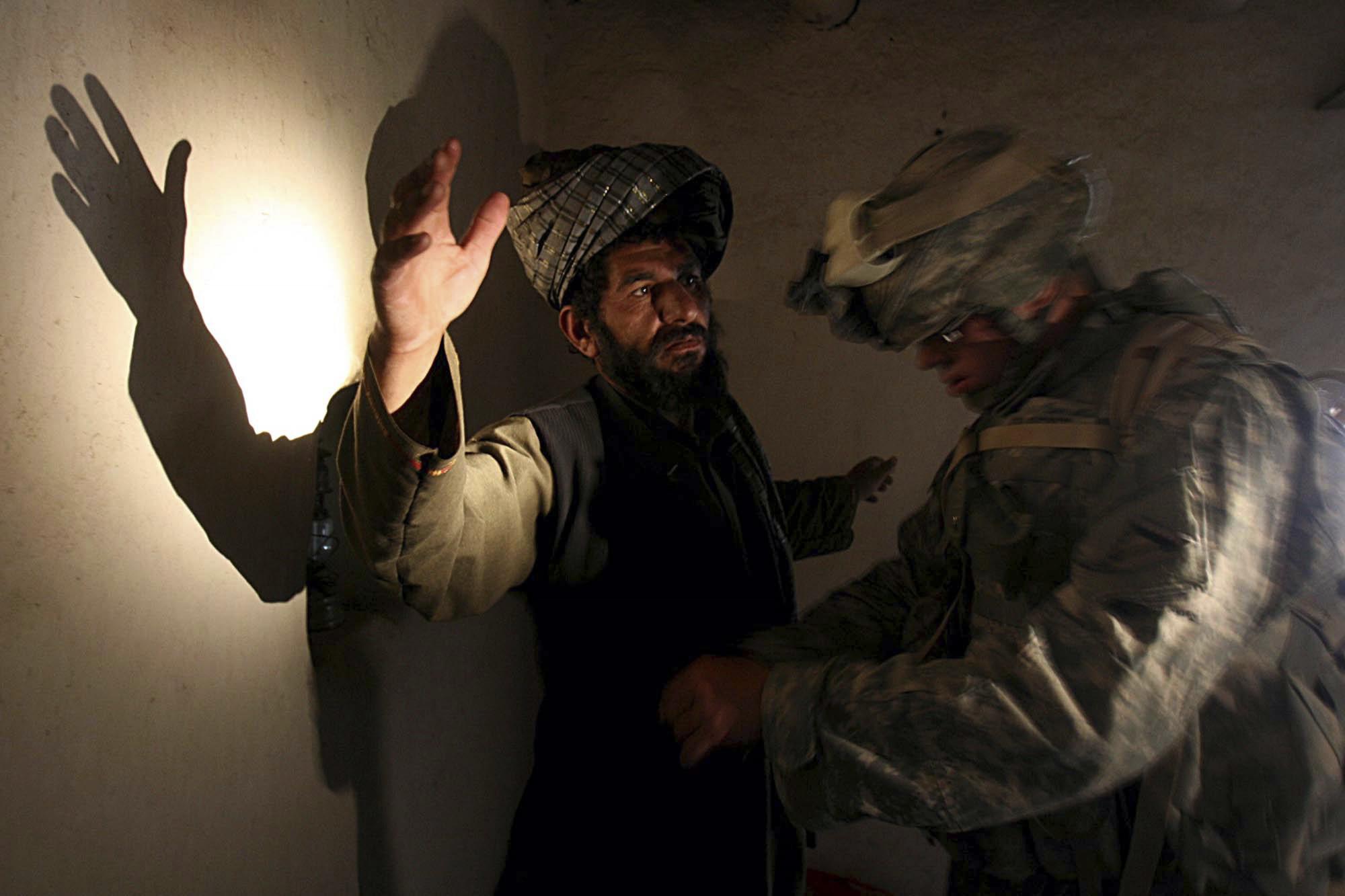 Un soldado estadounidense de la compañía B, 4to Regimiento de Infantería cachea a un hombre afgano en su casa durante una operación de búsqueda en la aldea de Sinan en la provincia de Zabul, sureste de Afganistán, el lunes 2 de abril de 2007 (Foto AP / Rafiq Maqbool).