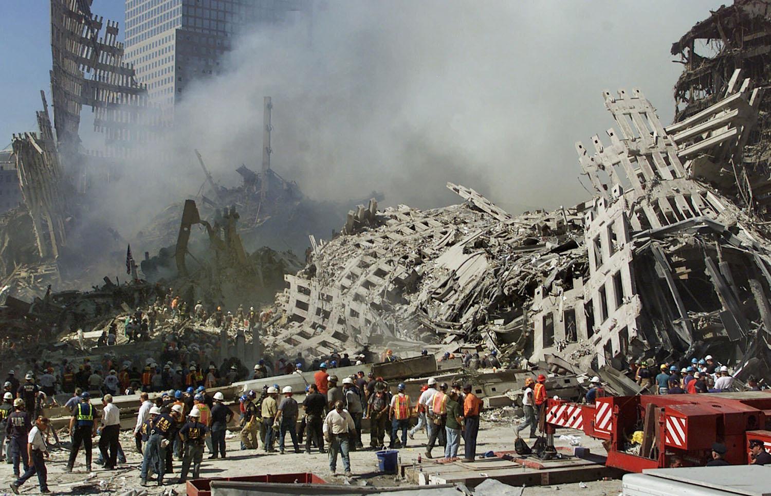 ARCHIVO - En esta fotografía de archivo del jueves 13 de septiembre de 2001, los rescatistas continúan su búsqueda mientras el humo se eleva de los escombros del World Trade Center en Nueva York. (Foto AP / Beth A. Keizer, archivo)