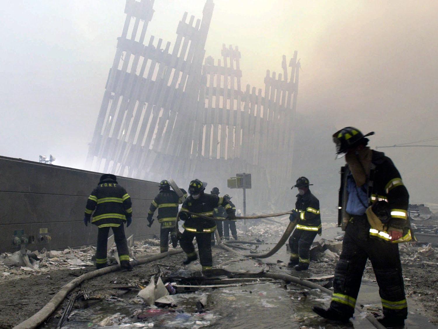 Los bomberos trabajan debajo de los montantes destruidos, los puntales verticales, del World Trade Center en Nueva York el martes 11 de septiembre de 2001. (Foto AP / Mark Lennihan)