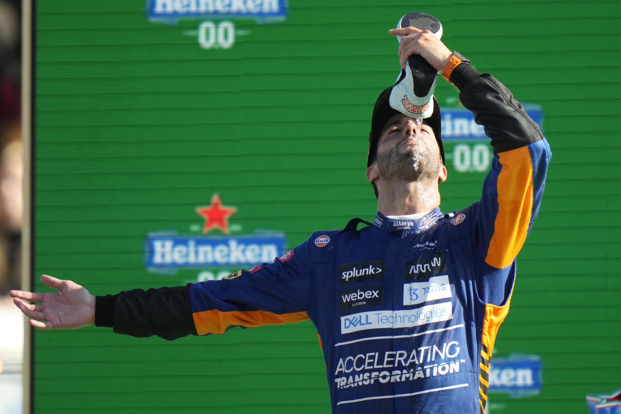El piloto australiano de Mclaren Daniel Ricciardo bebe champán de su zapato mientras celebra después de ganar el Gran Premio de Fórmula Uno de Italia, en el hipódromo de Monza, en Monza, Italia, el domingo 12 de septiembre de 2021. (AP Photo / Luca Bruno)
