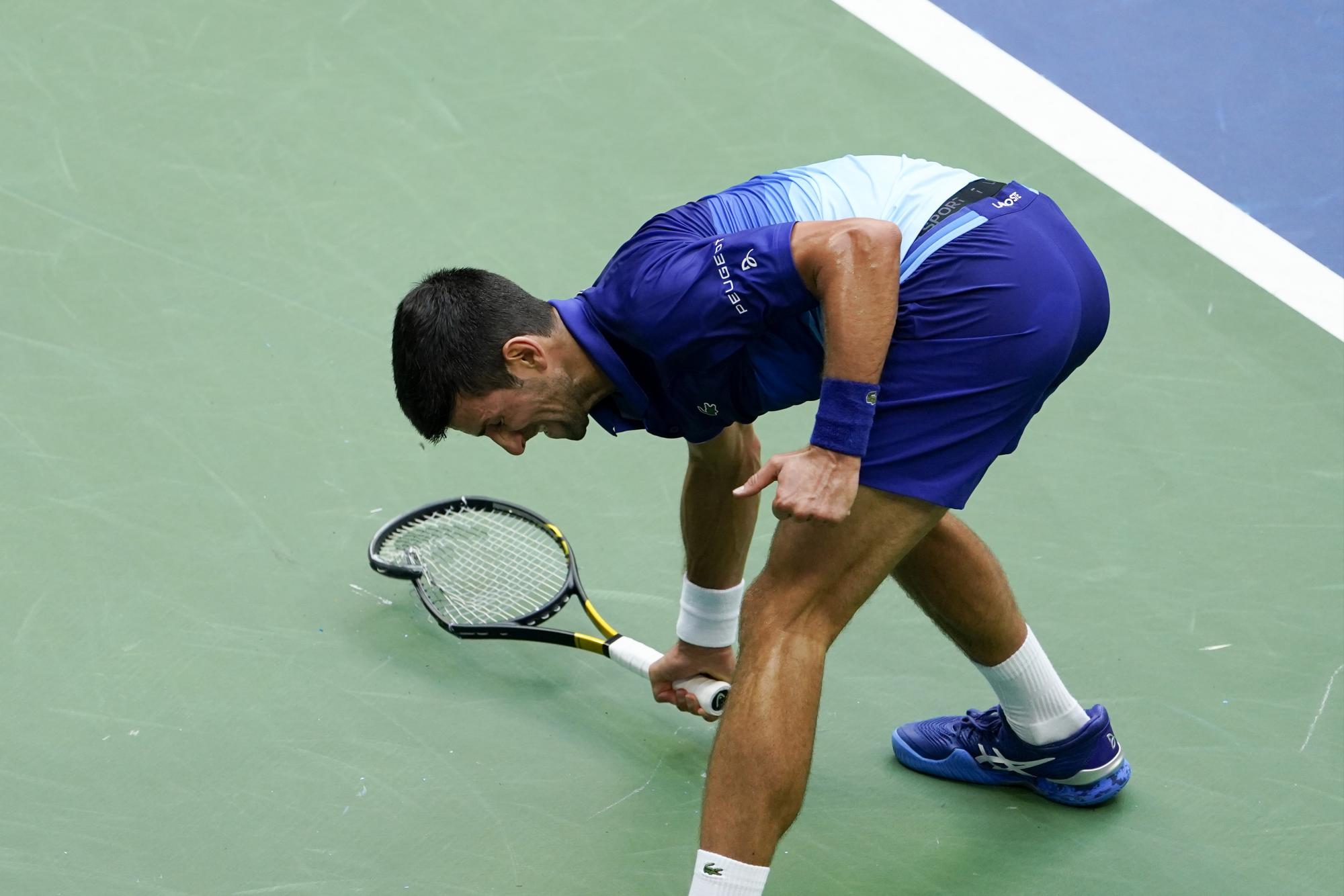 Novak Djokovic, de Serbia, rompe su raqueta en la cancha después de perder un punto ante Daniil Medvedev, de Rusia, durante la final masculina individual del campeonato de tenis del US Open, el domingo 12 de septiembre de 2021, en Nueva York. (Foto AP / Seth Wenig)