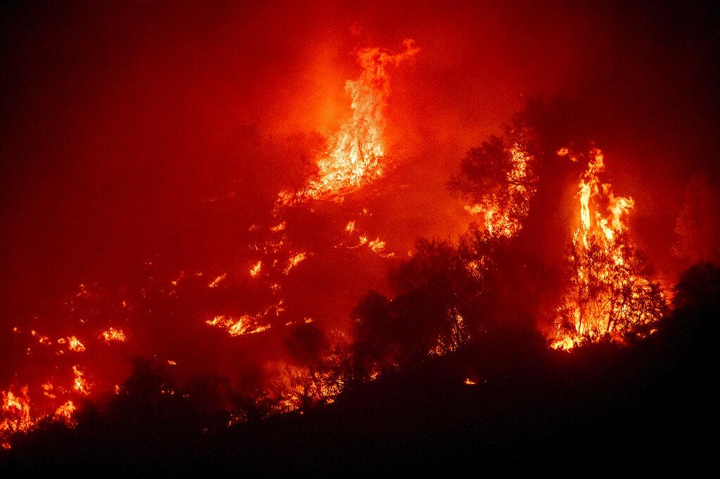Las llamas del incendio del complejo KNP queman una ladera sobre el río Kaweah en el Parque Nacional Sequoia, California, el martes 14 de septiembre de 2021. El incendio arde cerca del Bosque Gigante, hogar de más de 2.000 secuoyas gigantes. (Foto AP / Noah Berger)
