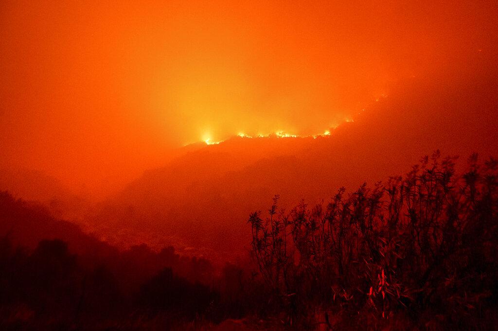 Las llamas del incendio del complejo KNP arden a lo largo de una ladera sobre el río Kaweah en el Parque Nacional Sequoia, California, el martes 14 de septiembre de 2021. El incendio arde cerca del Bosque Gigante, hogar de más de 2.000 secuoyas gigantes. (Foto AP / Noah Berger)