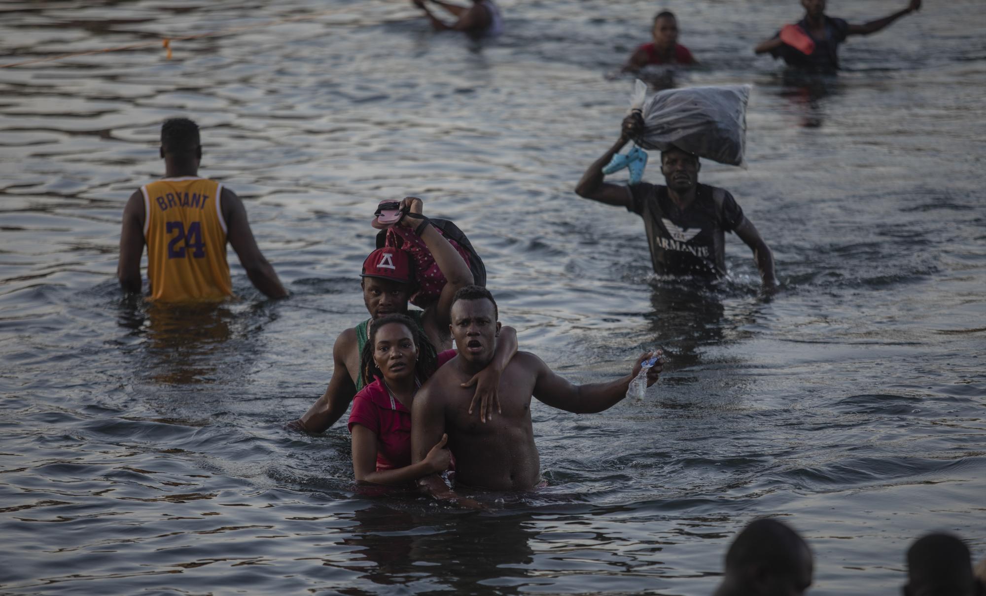 Migrantes haitianos cruzan el río Bravo desde Del Rio, Texas, a Ciudad Acuña, México, el domingo 19 de septiembre de 2021, para evitar la deportación a Haití desde los EE. UU. (AP Photo/Felix Marquez)