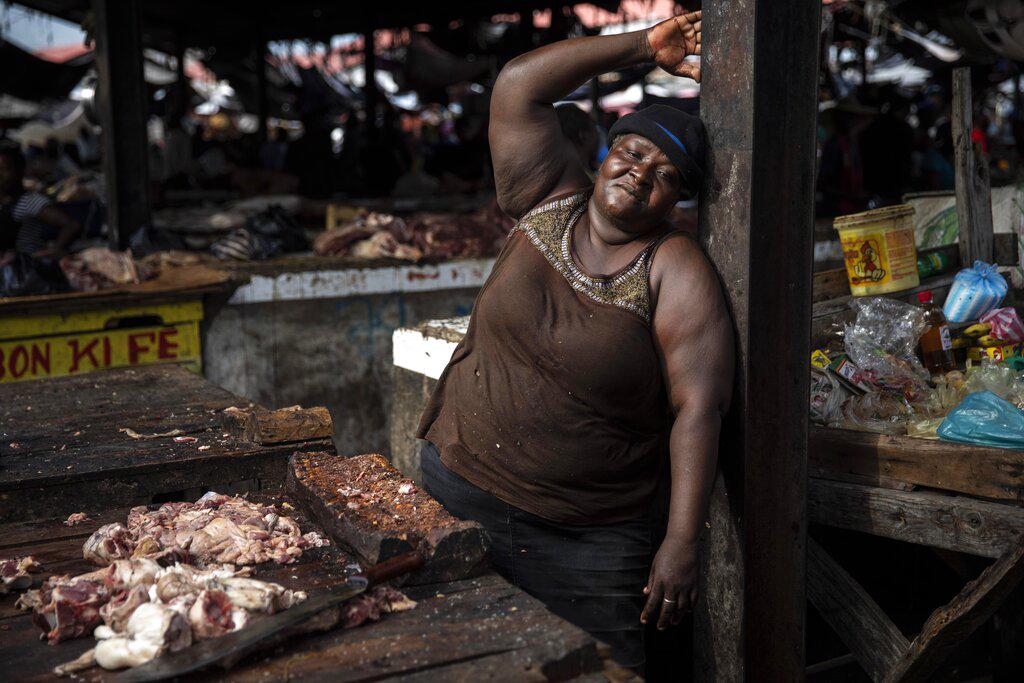 La vendedora Celestine posa para una foto mientras toma un descanso en su puesto de carnicero en un popular mercado en el centro de Puerto Príncipe, Haití. (AP Photo / Rodrigo Abd)