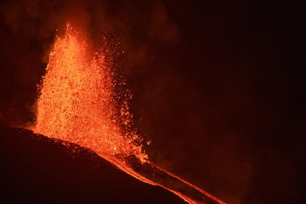 La lava fluye de un volcán en la isla canaria de La Palma, España, el lunes 27 de septiembre de 2021.. (AP Photo/Saul Santos)