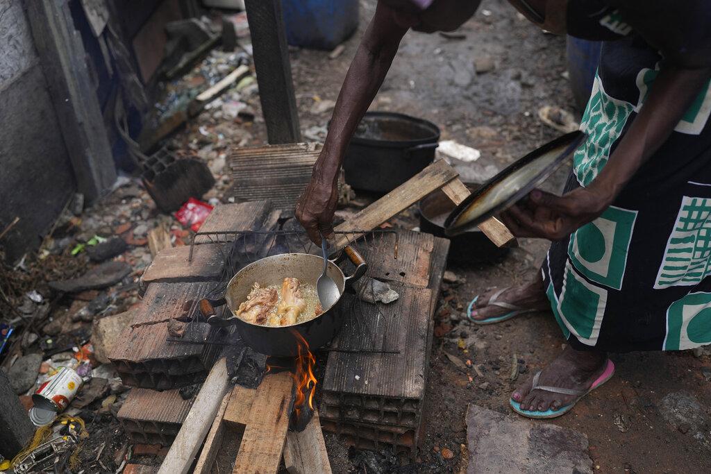 Cocinar con leña es la única opción para Laurentino, quien sufre junto a muchos de sus vecinos por los aumentos en el precio del gas. (AP Photo/Silvia Izquierdo)