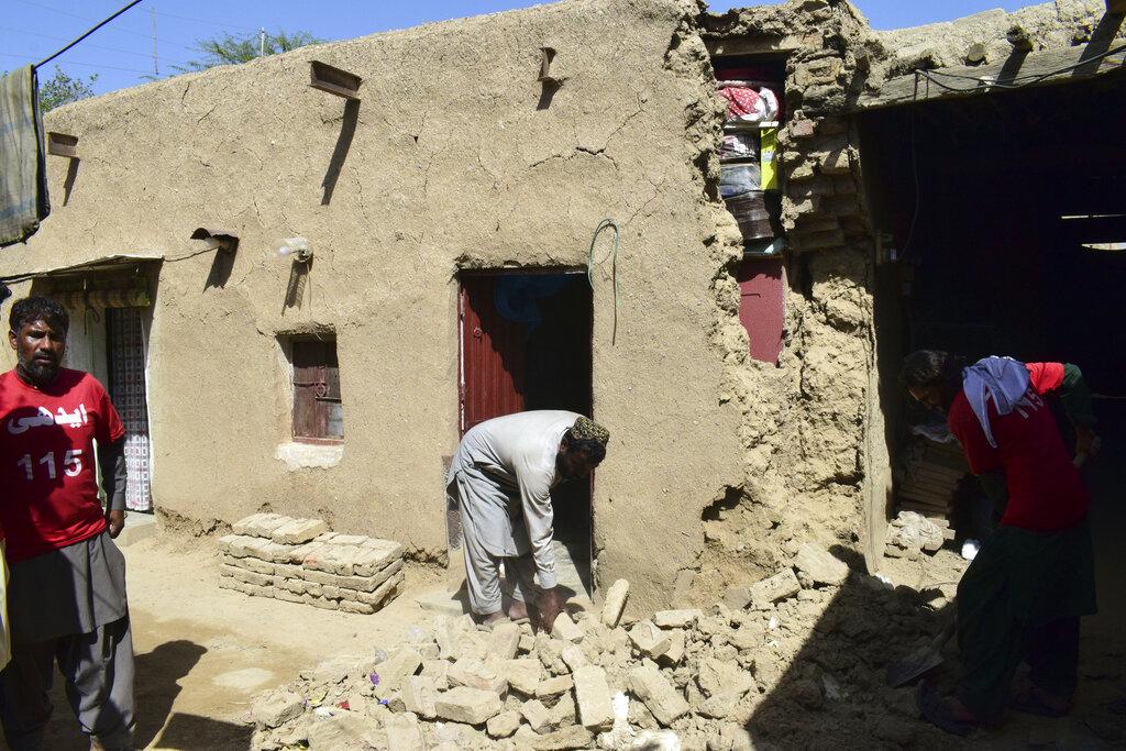 Un hombre limpia los escombros de una casa dañada tras un terremoto en Harnai, a unos 100 kilómetros (60 millas) al este de Quetta, Pakistán, el jueves 7 de octubre de 2021. El poderoso terremoto derrumbó al menos una mina de carbón y docenas de casas de adobe en el suroeste de Pakistán la madrugada del jueves. (Foto AP / Arshad Butt)