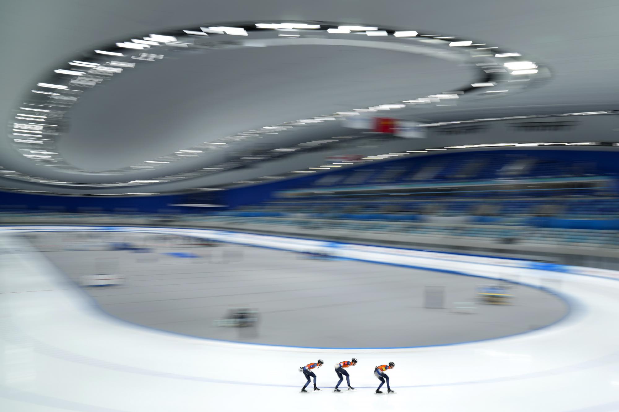 En esta foto tomada con una velocidad de obturación larga, los miembros del equipo holandés compiten en la persecución masculina durante el Speed ??Skating China Open, un evento de prueba para los Juegos Olímpicos de Invierno de 2022, en el National Speed ??Skating Oval en Beijing, el sábado 9 de octubre. , 2021. (Foto AP / Mark Schiefelbein)