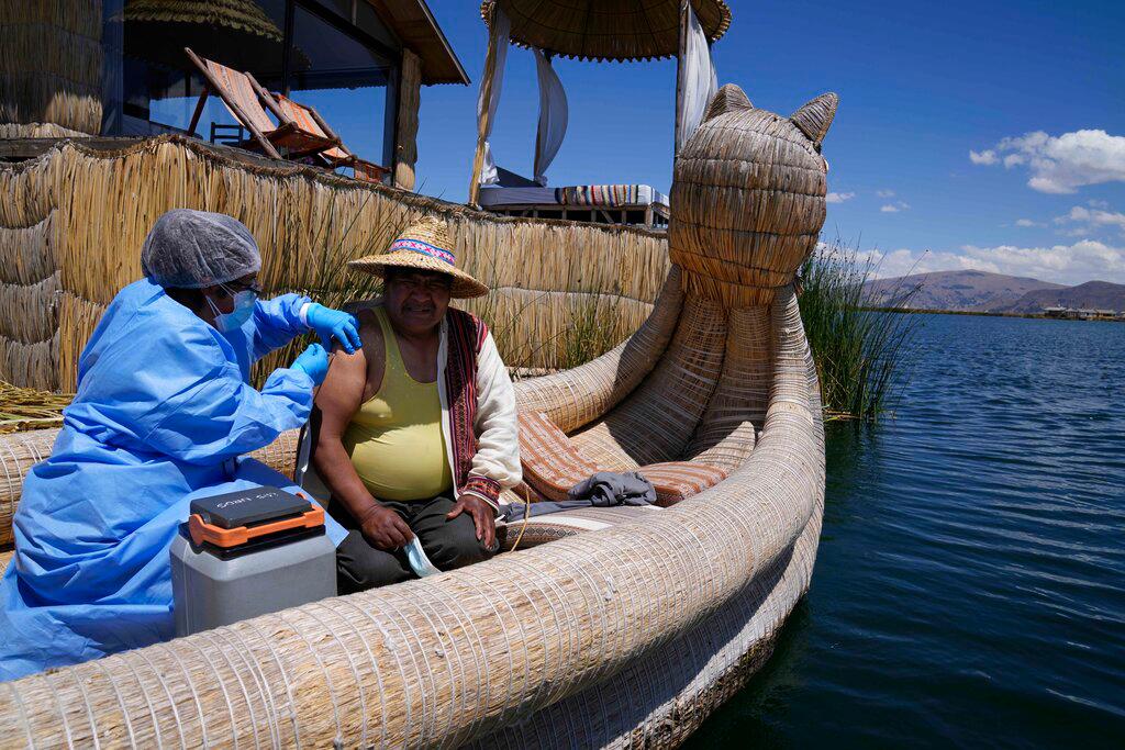 Una trabajadora de la salud inyecta a Julio Vilca una dosis de la vacuna de Pfizer para el COVID-19 durante una campaña de vacunación puerta a puerta dirigida a los residentes del lago Titicaca en Puno, Perú, el miércoles 27 de octubre de 2021. 
