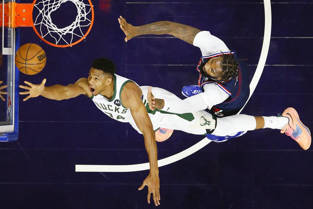 Giannis Antetokounmpo de los Milwaukee Bucks, a la izquierda, dispara sobre Andre Drummond de los 76ers de Filadelfia durante la primera mitad de un partido de baloncesto de la NBA, el martes 9 de noviembre de 2021 en Filadelfia. (Foto AP / Matt Slocum)