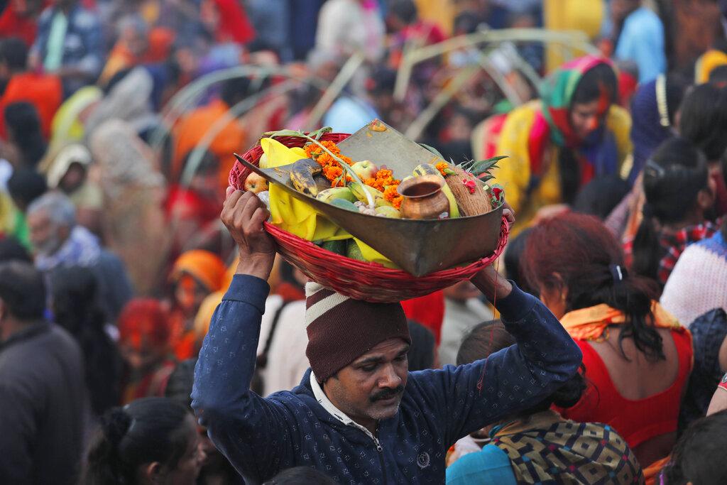 Un devoto hindú lleva material utilizado para las ofrendas al Dios Sol en el río Yamuna durante el festival Chhath en Prayagraj, India. Jueves, 11 de noviembre de 2021. Durante Chhath, un antiguo festival hindú, se realizan rituales para agradecer al dios Sol por mantener la vida en la tierra y buscar las bendiciones divinas. (Foto AP / Rajesh Kumar Singh)