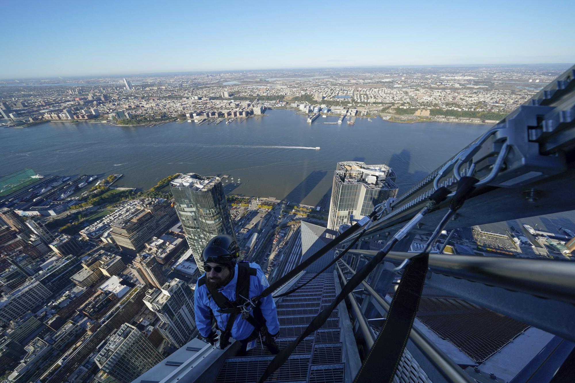 Enzo Gentile, parte del personal de mantenimiento, sube por una escalera de la parte exterior del rascacielos en 30 Hudson Yards en Nueva York el 3 de noviembre del 2021.  (AP Photo/Seth Wenig)