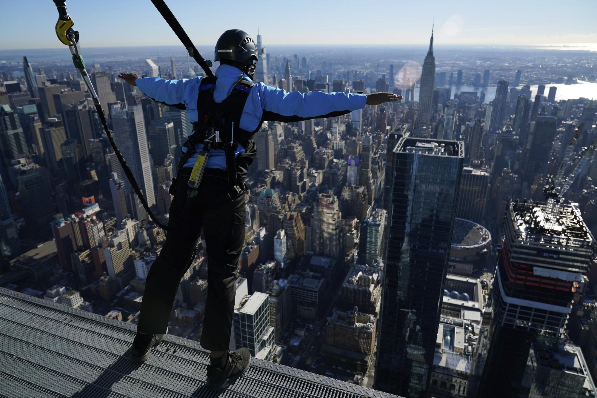 Una persona disfruta de las vistas de Nueva York desde la plataforma más alta de edificio 30 Hudson Yards, sostenido por sogas, el 3 de noviembre del 2021. (AP Photo/Seth Wenig)