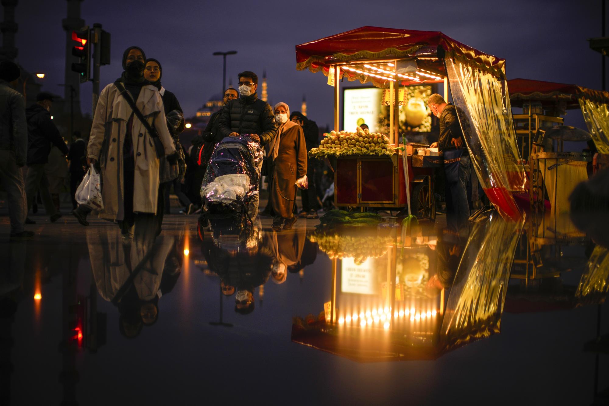 Un vendedor tuesta castañas y mazorcas de maíz mientras espera clientes en el distrito de Eminonu en Estambul, Turquía, el viernes 19 de noviembre de 2021. (AP Photo / Francisco Seco)