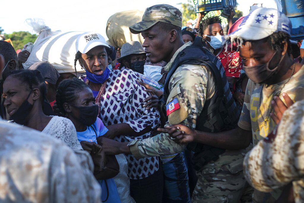 Una policía haitiana intenta mantener el orden mientras los haitianos intentan cruzar a la República Dominicana, en un puente fronterizo en Dajabón, República Dominicana, el viernes 19 de noviembre de 2021. Los viernes son uno de los días más concurridos en el mercado binacional entre Haití y el República Dominicana. (Foto AP / Matias Delacroix)