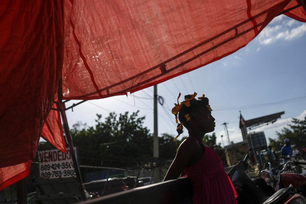 Una niña bajo un toldo en el cruce fronterizo de Dajabón, República Dominicana, el viernes 19 de noviembre de 2021. Los viernes son uno de los días más concurridos en el mercado binacional entre Haití y República Dominicana. (Foto AP / Matias Delacroix)