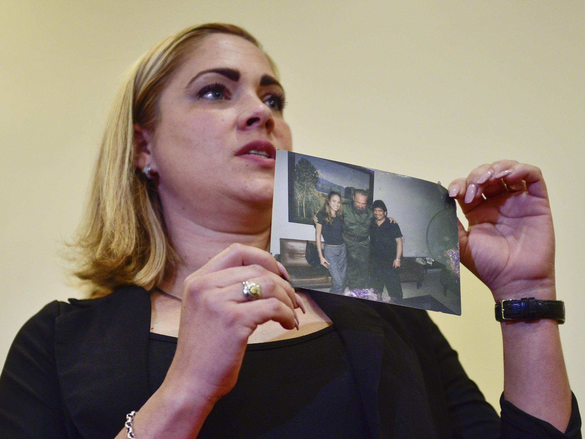 Mavys Álvarez muestra una foto en la que aparece junto a Diego Maradona y Fidel Castro, durante una rueda de prensa en Buenos Aires, Argentina, el lunes 22 de noviembre. La mujer cubana impulsa una denuncia por supuesta trata de personas de la que fue víctima mientras estuvo en pareja con el fallecido astro Diego Maradona. (AP/Gustavo Garello).