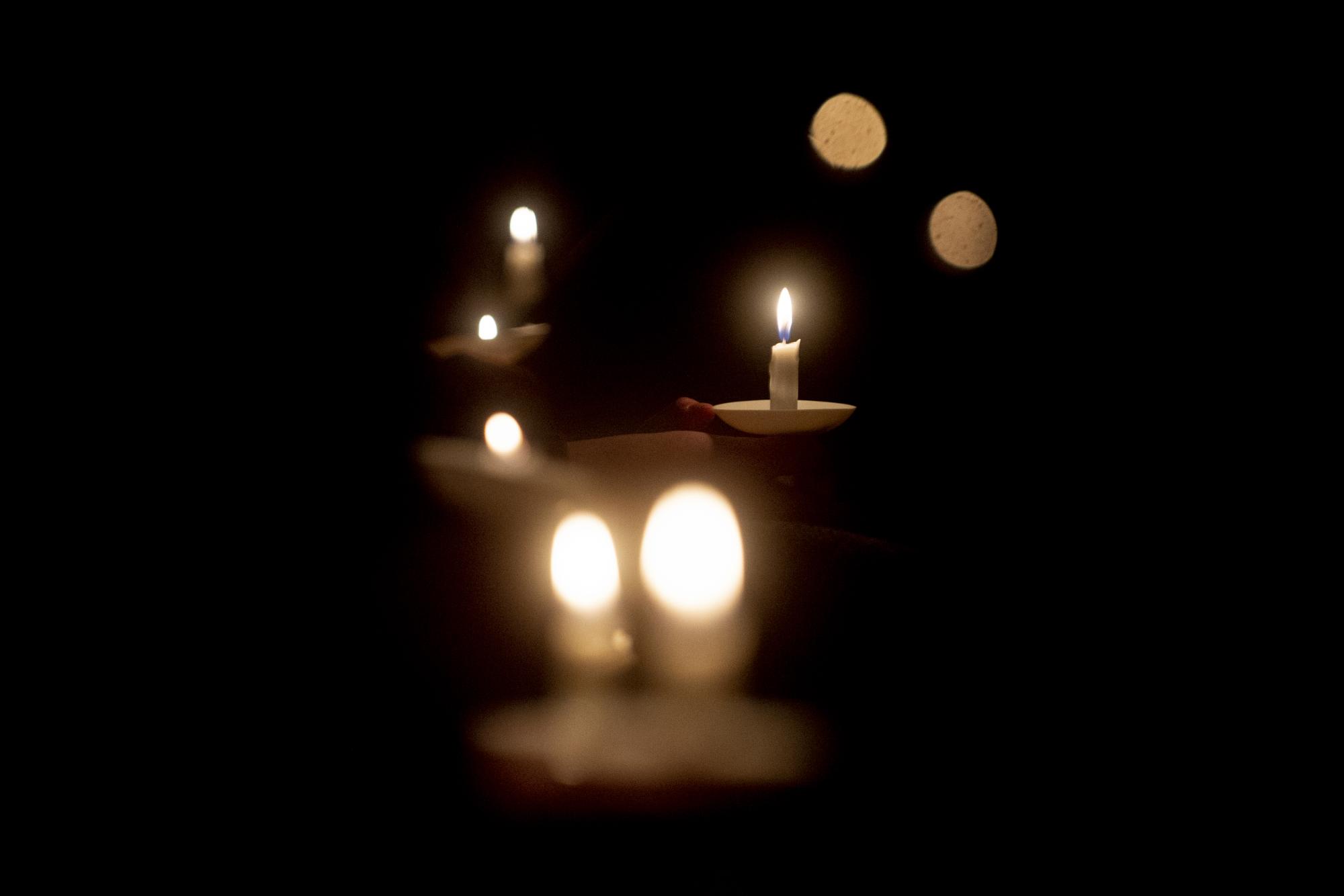 Las personas sostienen velas durante una vigilia de oración después de los tiroteos en la escuela secundaria de Oxford, el martes 30 de noviembre de 2021, en LakePoint Community Church en Oxford, Michigan (Jake May / The Flint Journal vía AP)