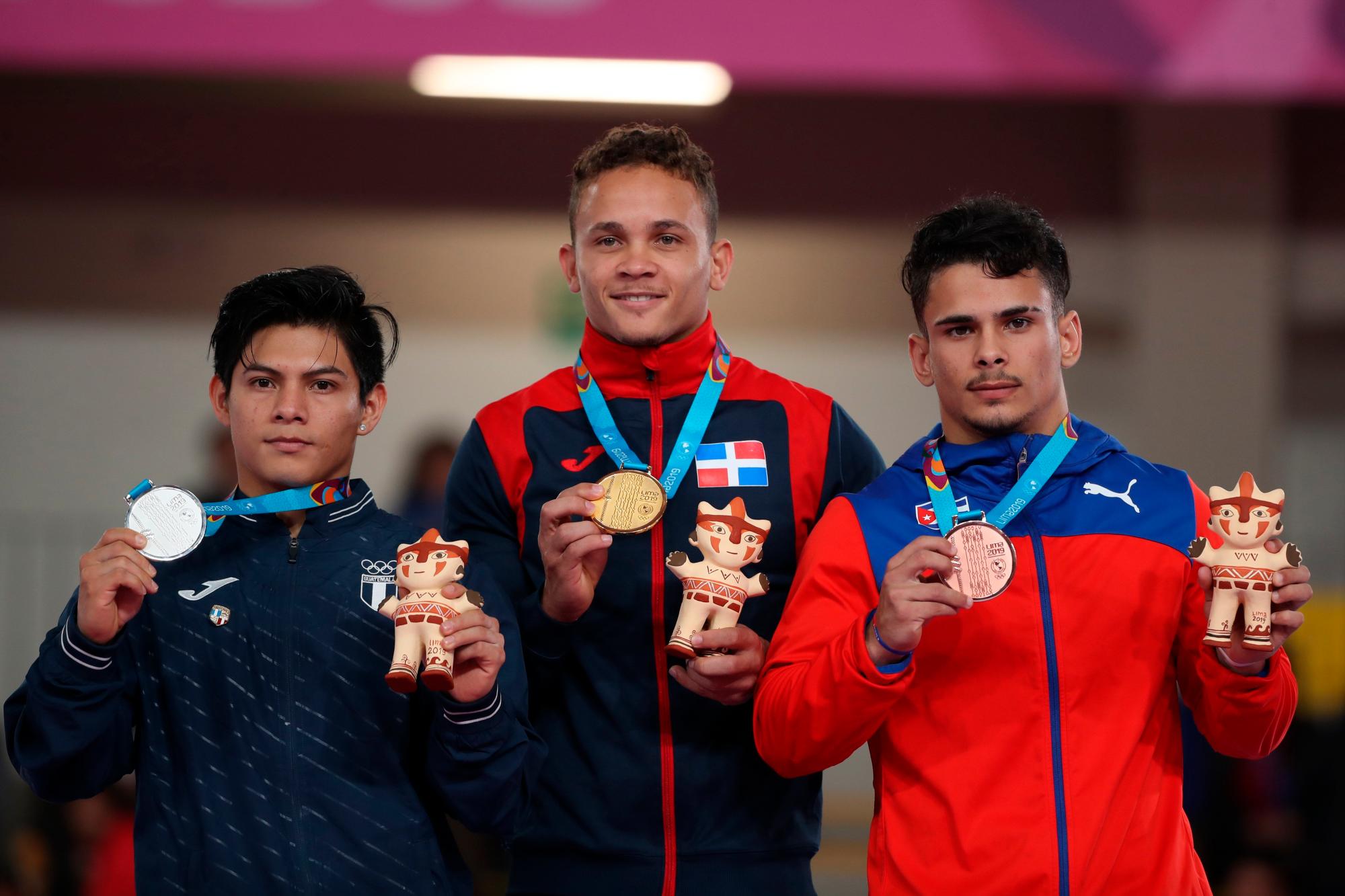 Audrys Nin (c) de República Dominicana, medalla de oro, posa junto a Jorge Vega de Guatemala, plata, y Alejandro de la Cruz, bronce, en la premiación de salto masculino de la gimnasia artística este miércoles en los Juegos Panamericanos Lima 2019, en Lima (Perú). 