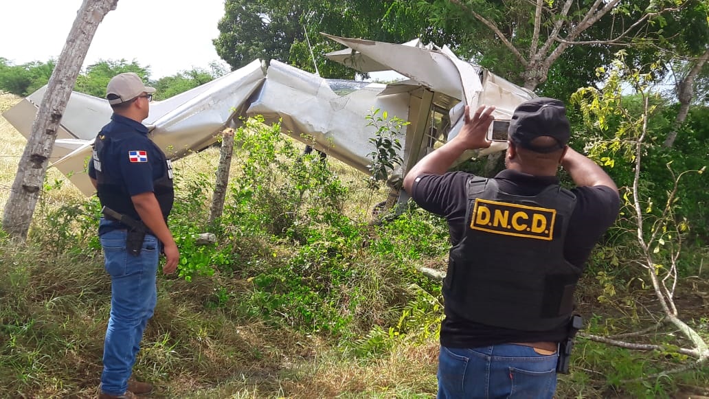 Agentes de la DNCD hacen imágenes de la aeronave precipitada en la comunidad Boca de Yuma.