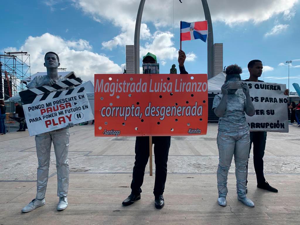 Estos jóvenes realizan un performance pidiendo democracia. 
