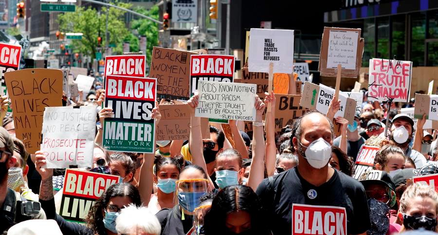 Manifestantes sostienen carteles mientras protestan frente a Times Square en Nueva York, Estados Unidos, el 7 de junio de 2020, por la muerte de George Floyd.