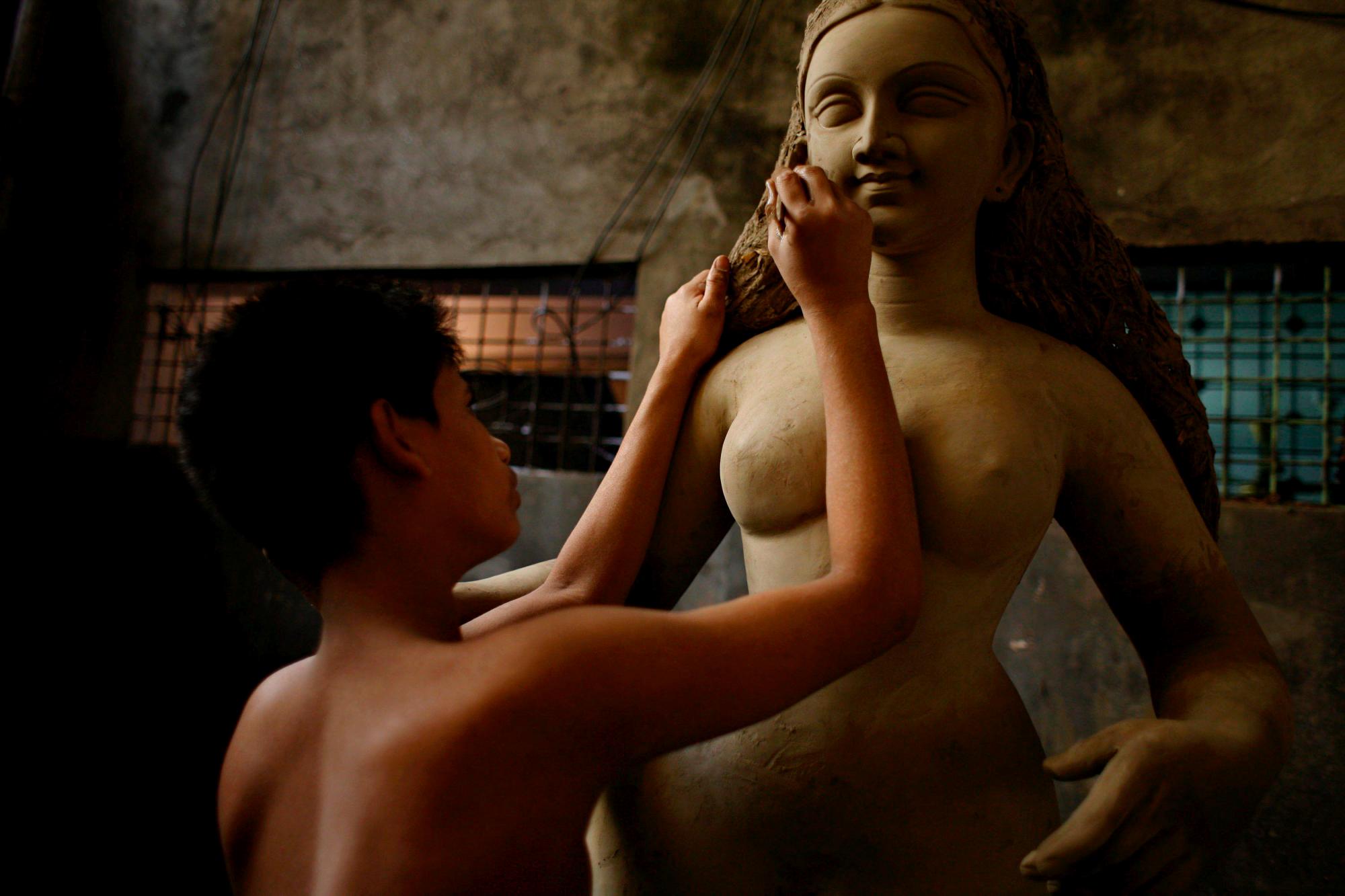 Un artista bangladesí trabaja en la escultura de barro de una diosa hindú durante los preparativos para la festividad religiosa Durga Puja, dedicada a la diosa Durga, en Shankari Bazaar, Dhaka, Bangladesh (2008).