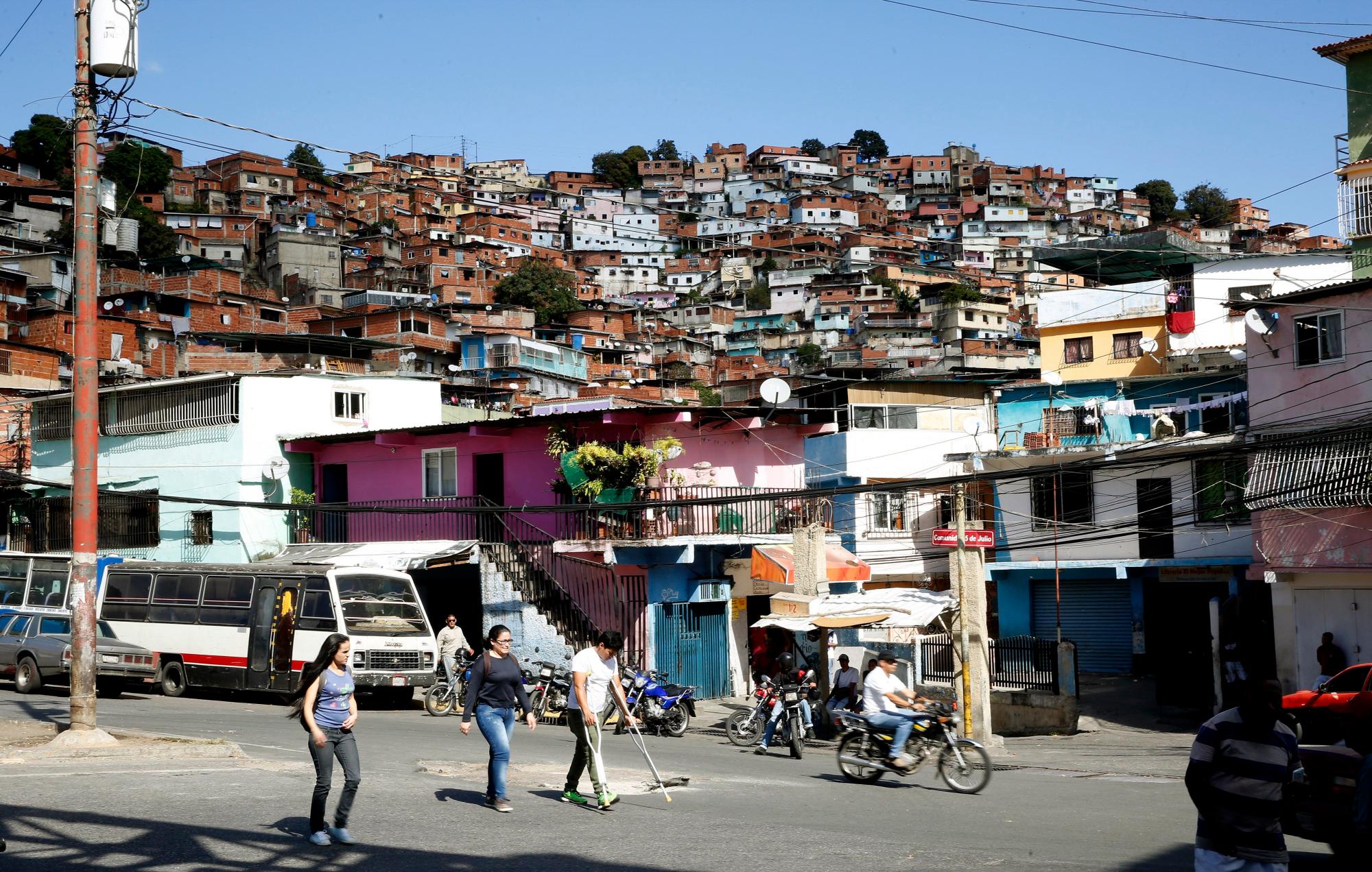 Habitantes del barrio 5 de julio caminan hoy, sábado 26 de enero de 2019, en Caracas (Venezuela).