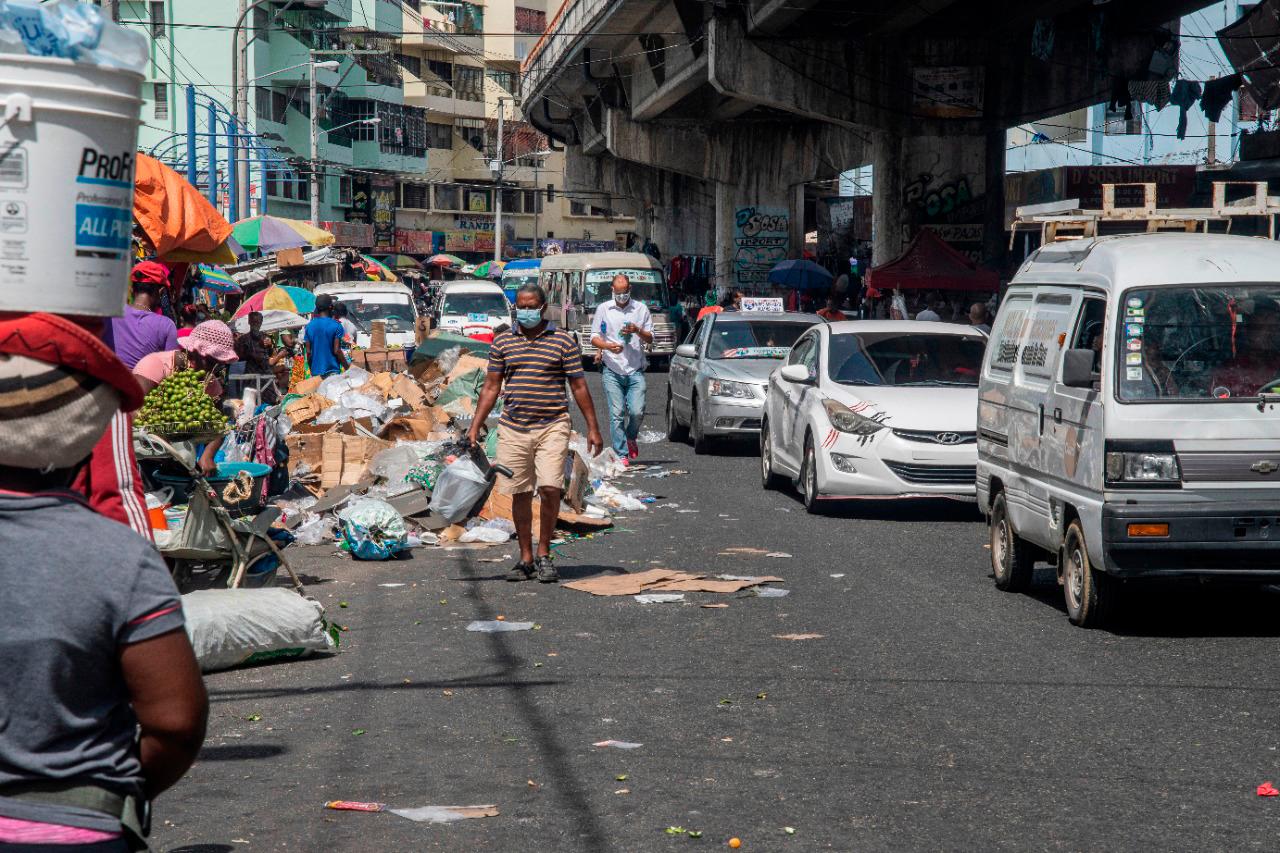 Los transeúntes se ven obligados a caminar entre los vehículos ya que los comerciantes y la basura acaparan la acera.