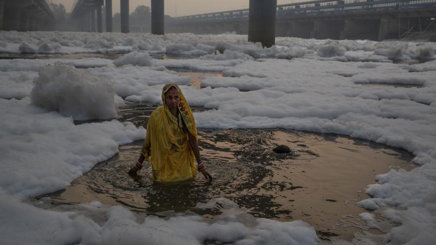 Hindúes se bañan en río sagrado cubierto de espuma tóxica