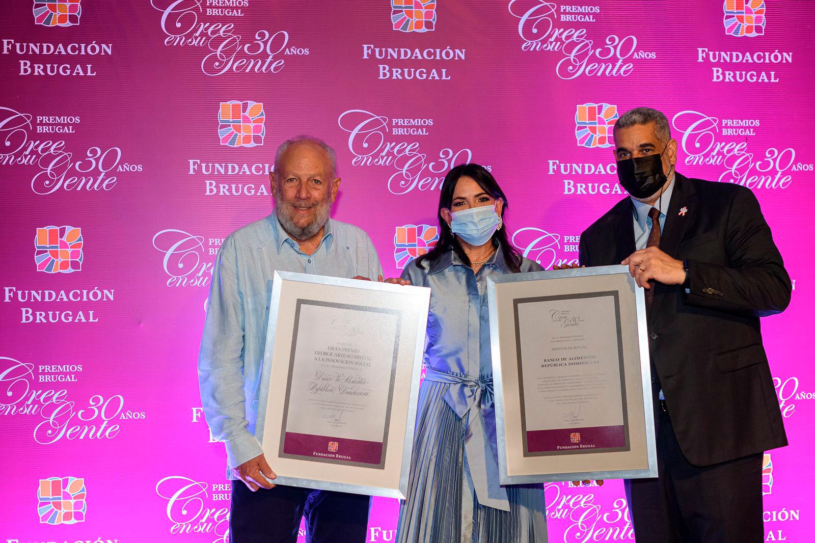 Julinna Staffeld con Freddy Ginebra y Carlos Ortega, VP de la junta de directores del Banco de Alimentos.