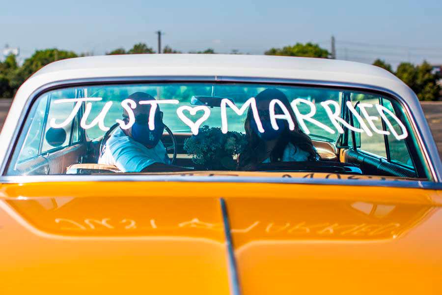 Philip Hernández y Marcela Perú posan para una foto dentro de un automóvil en el estacionamiento del Honda Center después de la boda.  
