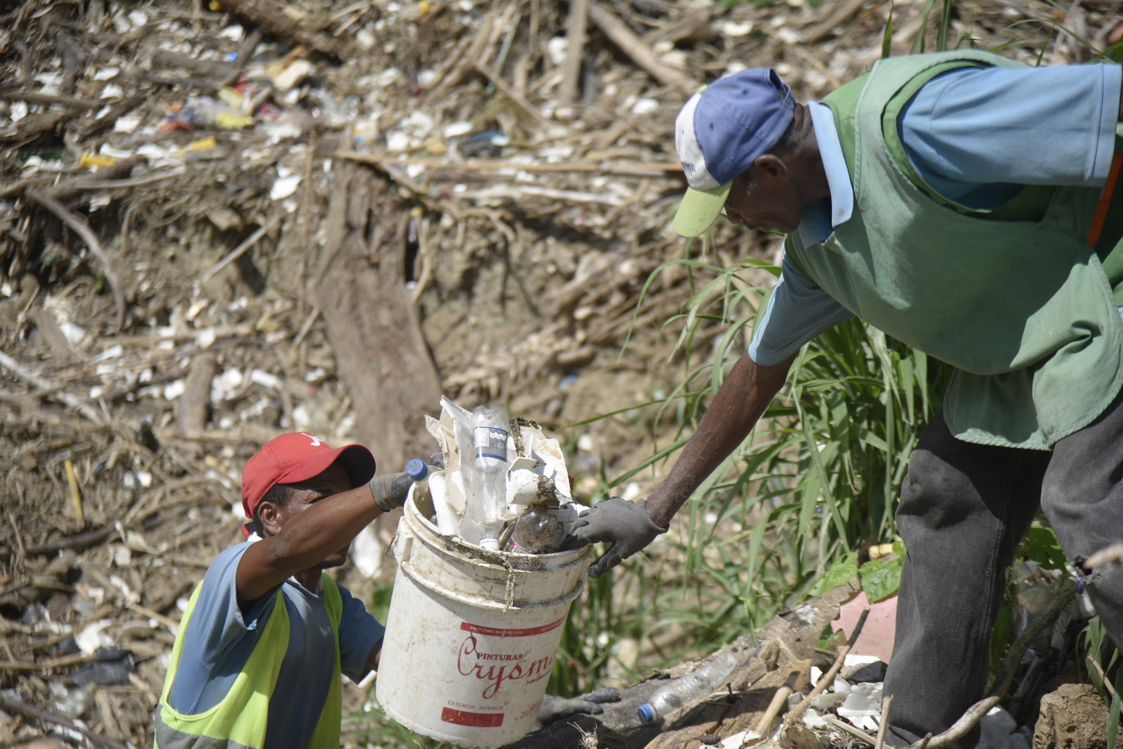Empleados del Ayuntamiento de Santiago mientras retiran con cubetas los desperdicios de una de las cañadas. 