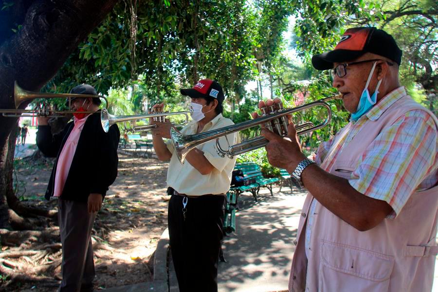 Integrantes de una banda musical actúan en una calle a cambio de una ayuda para una olla común, el miércoles 20 de mayo de 2020, en Santa Cruz (Bolivia). Trompetas, tambores y platillos animan a los transeúntes a cambio de una ayuda para comer, en estos tiempos en los que hasta la música se queda sin clientes en Bolivia. 