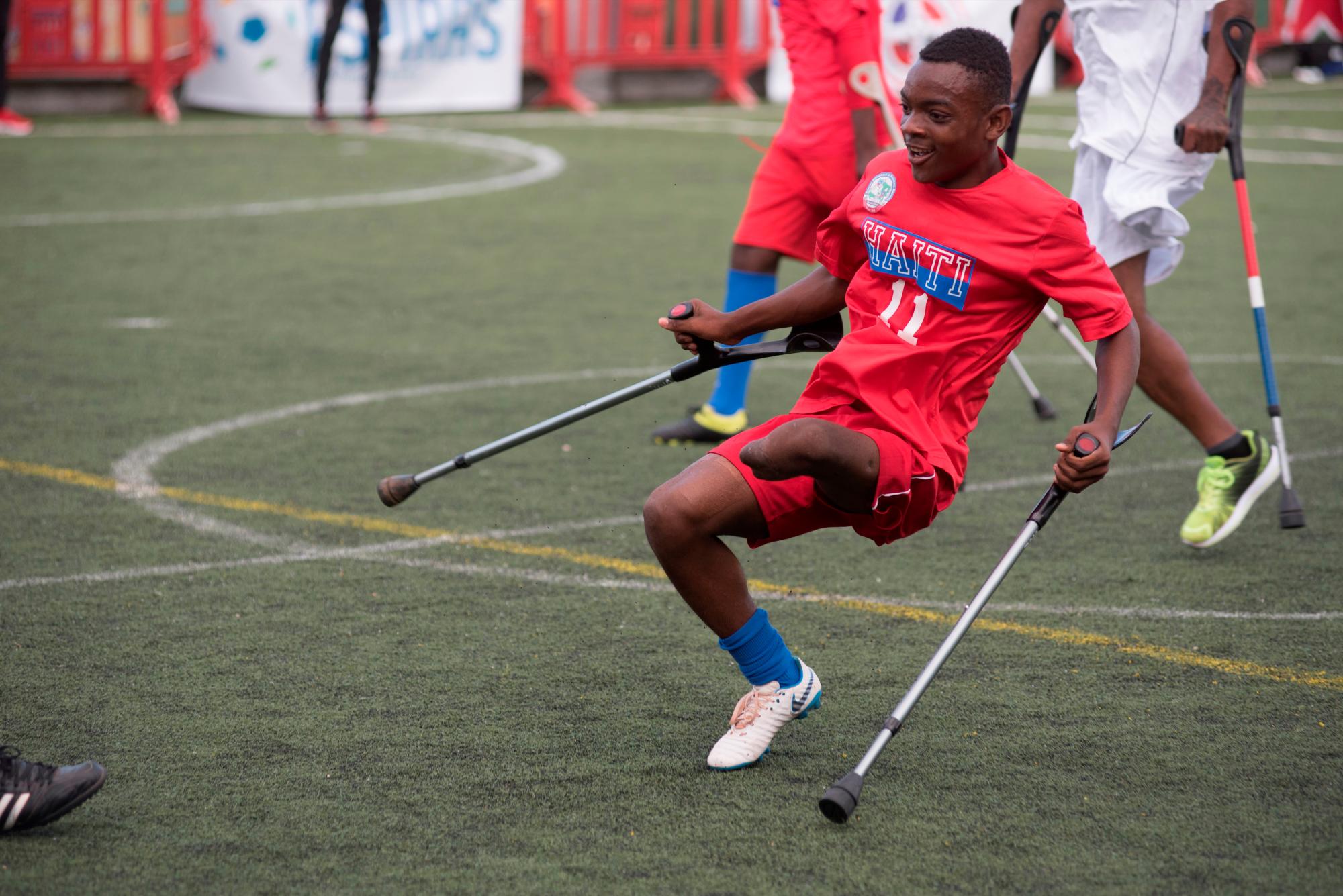 Un jugador de fútbol del equipo de Haití, víctima del terremoto 2010 ataca la portería del equipo dominicano, en el marco del evento “Dos muletas y un balón” con motivo del décimo aniversario del terremoto de Haití, en Santo Domingo (República Dominicana). 