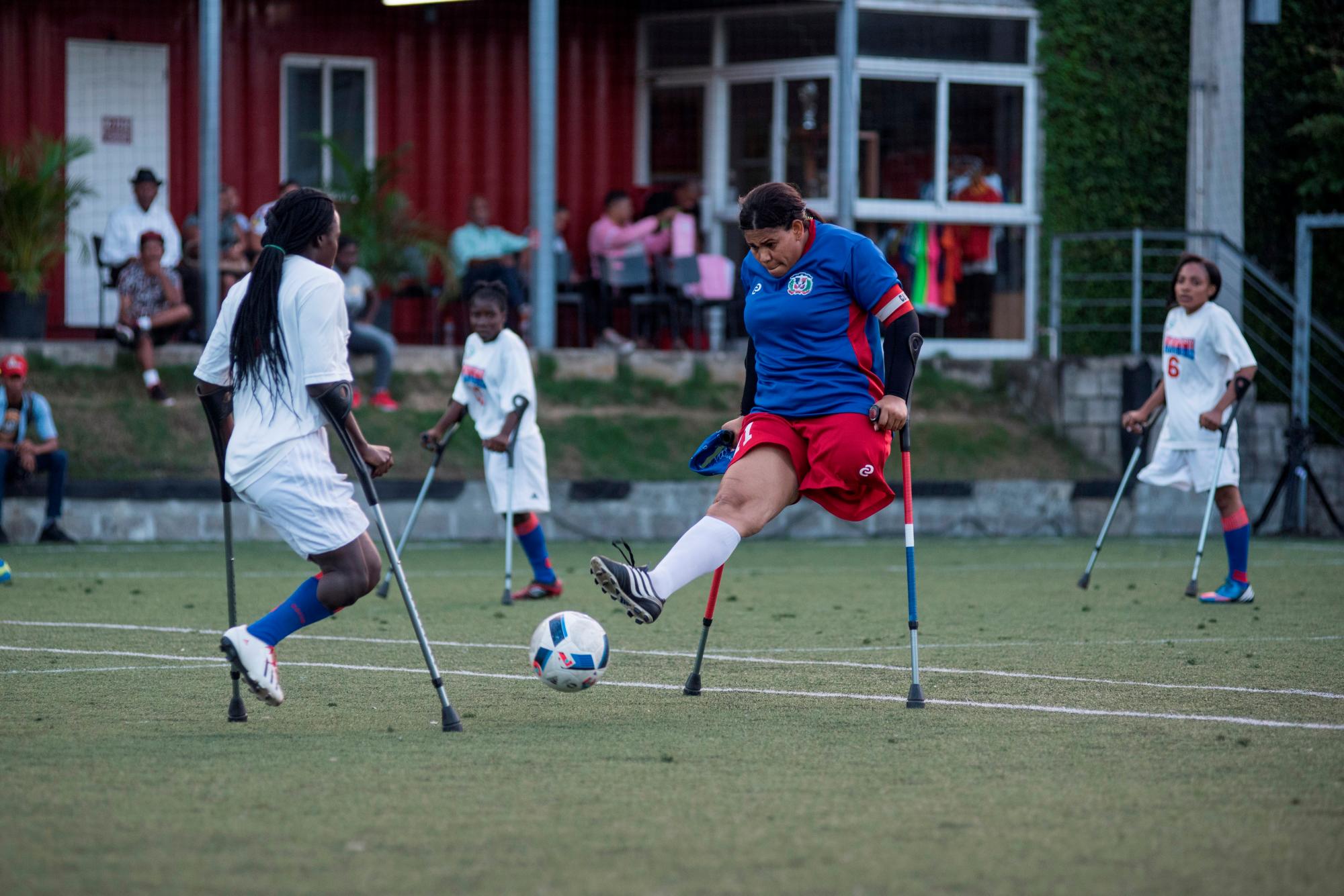 Una jugadora de fútbol de la selección femenina de República Dominicana corre con el balón por el medio campo en el marco del evento “Dos muletas y un balón” con motivo del décimo aniversario del terremoto de Haití, en Santo Domingo (República Dominicana). 