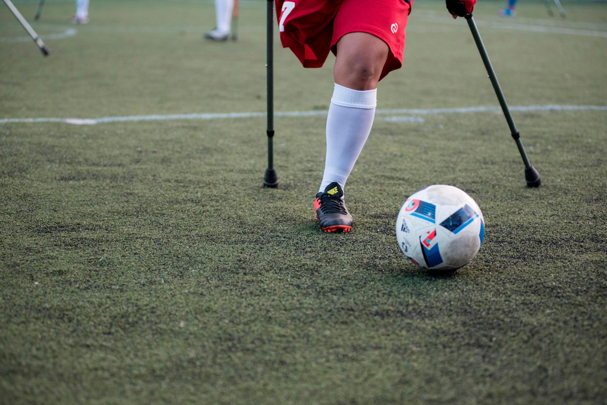 Detalle de jugadora de fútbol de la selección femenina de República Dominicana junto al balón de fútbol en el evento “Dos muletas y un balón” con motivo del décimo aniversario del terremoto de Haití, en Santo Domingo (República Dominicana). 