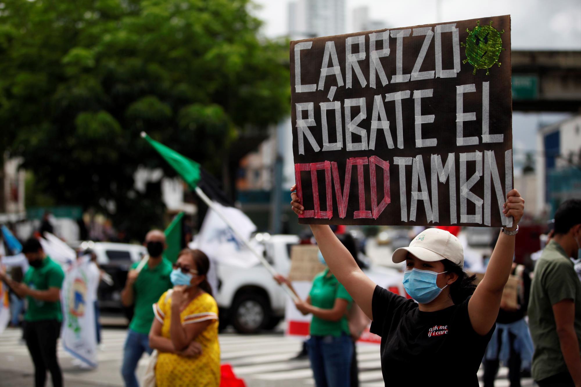 Una mujer sostiene un cartel de protesta este miércoles, en las afueras de la Asamblea Nacional de Panamá, en donde el presidente de la nación, Laurentino Cortizo, ofrece ante el parlamento su discurso por su primer año de mandato (EFE/ Bienvenido Velasco)