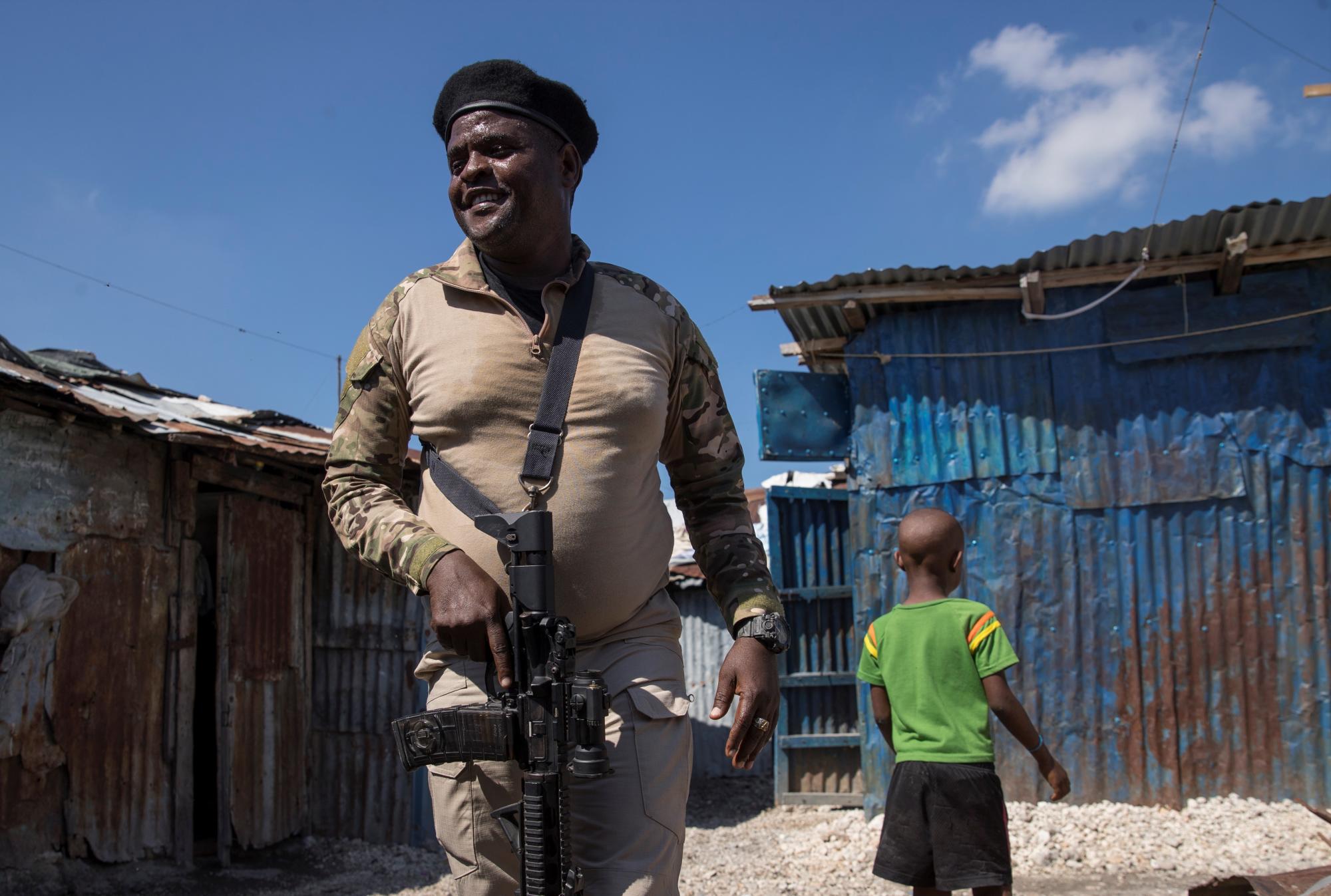 El líder de la principal banda armada de Haití, Jimmy Cherizier, alias Barbecue, vestido de militar y armado, camina hoy por una calle del barrio La Saline, en Puerto Príncipe (Haití). EFE/ Orlando Barría