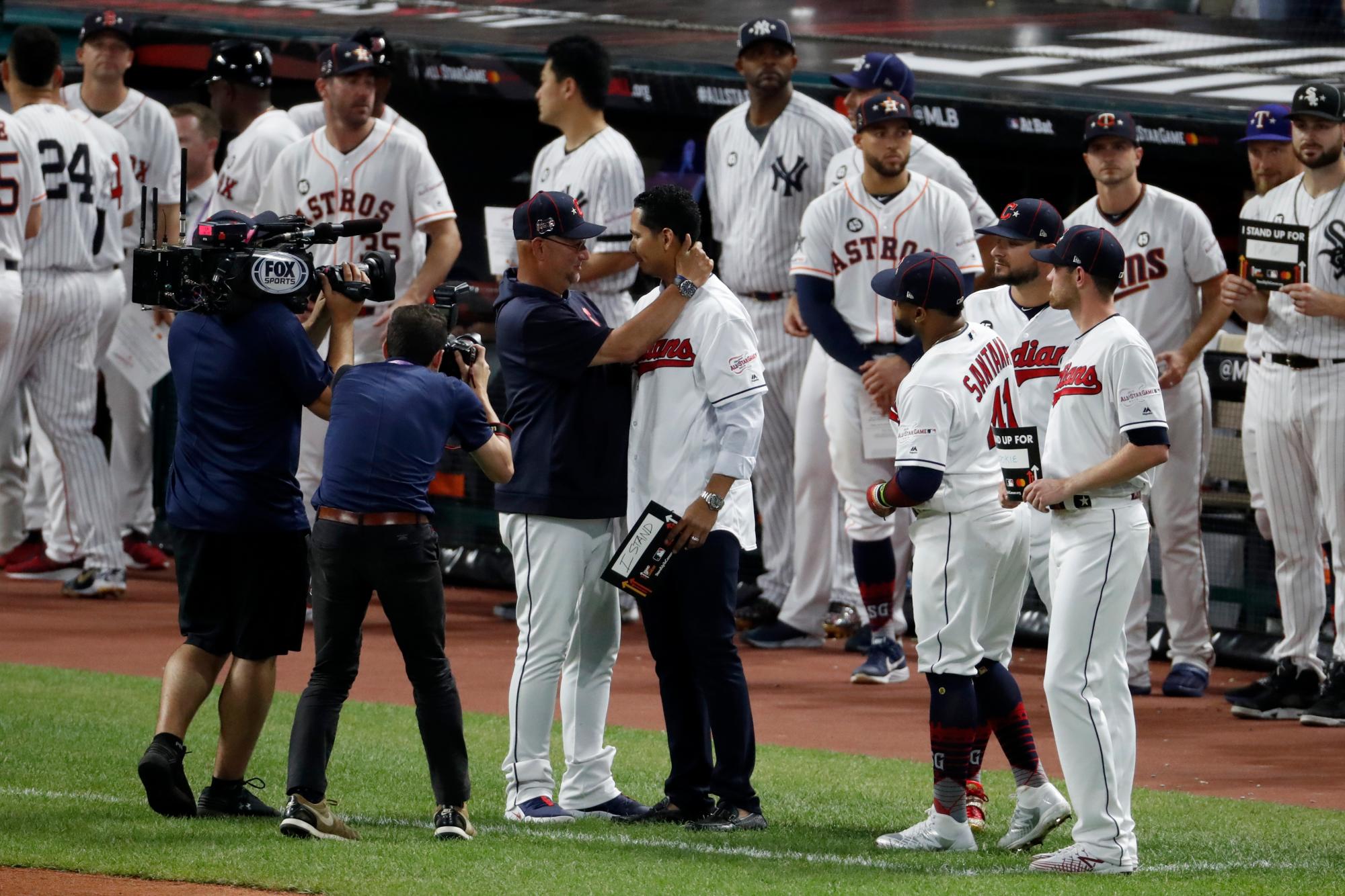 El mánager de los Indios de Cleveland, Terry Francona, a la izquierda, abraza al lanzador de los Indios Carlos Carrasco durante la mitad de la quinta entrada del Juego de las Estrellas de béisbol de las Grandes Ligas, el martes 9 de julio de 2019, en Cleveland. El diestro de los Indios, a quien recientemente se le diagnosticó una forma de leucemia, fue saludado en la quinta entrada del juego como parte de la campaña “Stand Up to Cancer” de la Major League Baseball.