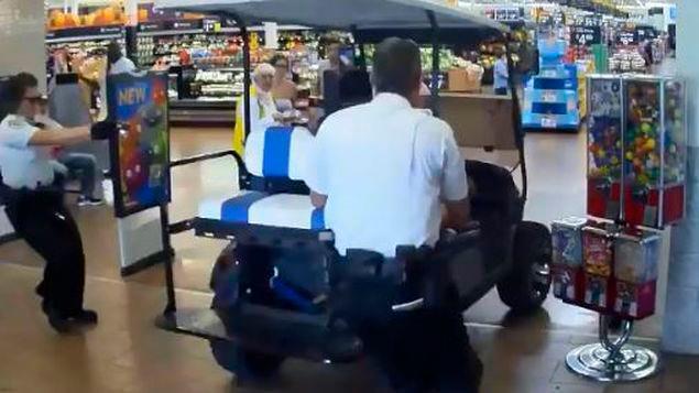 Hombre conduce carrito de golf dentro de un supermercado 