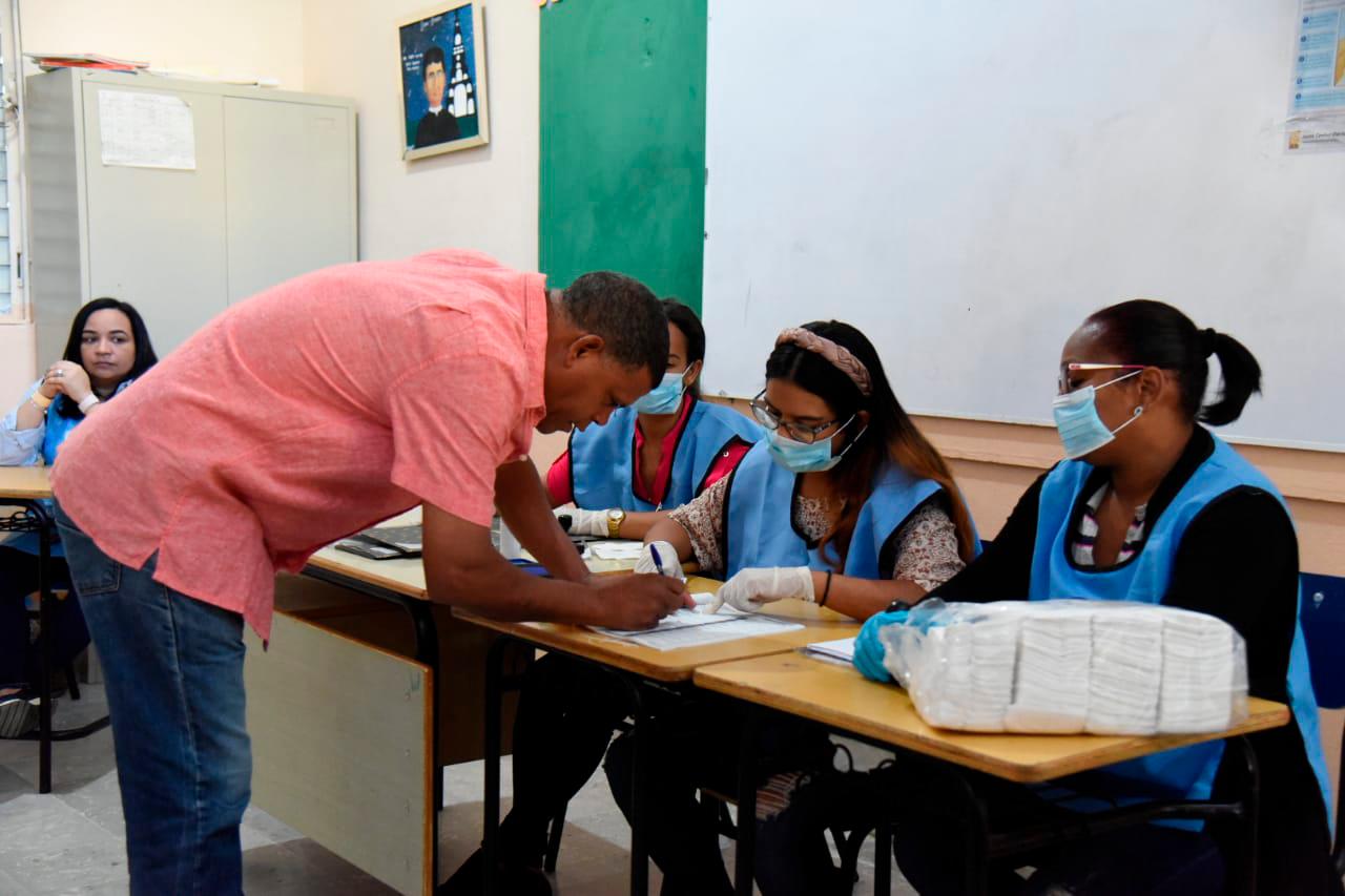 Funcionarios de una colegio electoral se protegen con mascarillas durante las votaciones de este 15 de marzo de 2020.