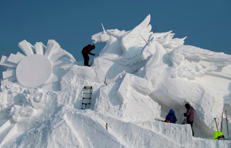 Obreros ponen el último toque a una escultura de hielo el 4 de enero de 2020 previo a la apertura del Festival Anual de Harbin, en China.